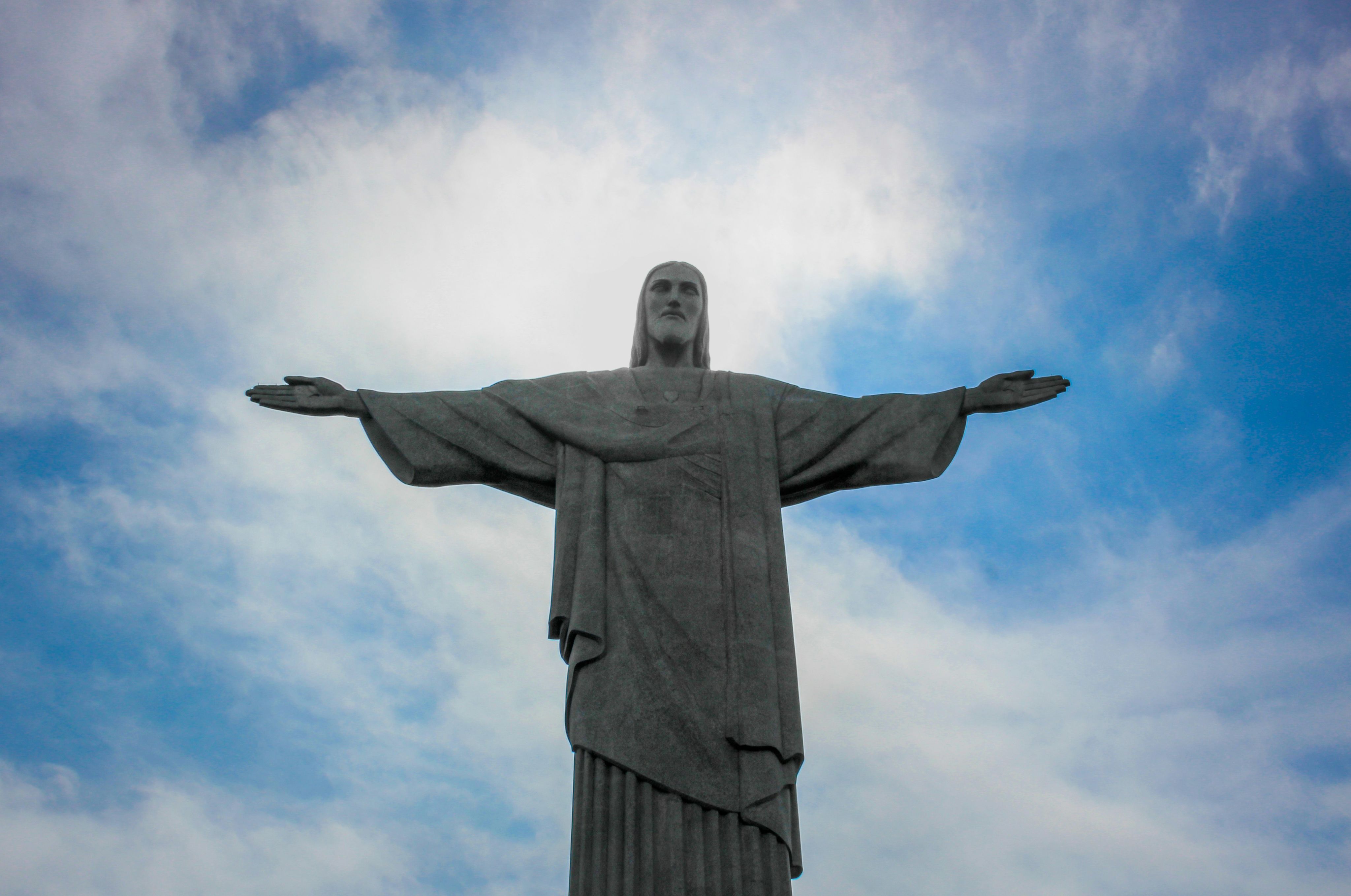 low angle photography of gray concrete statue under blue sky during daytime