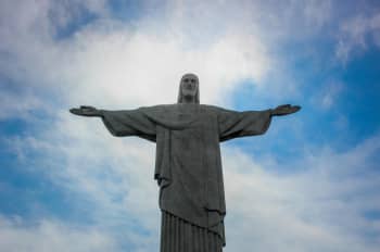 low angle photography of gray concrete statue under blue sky during daytime